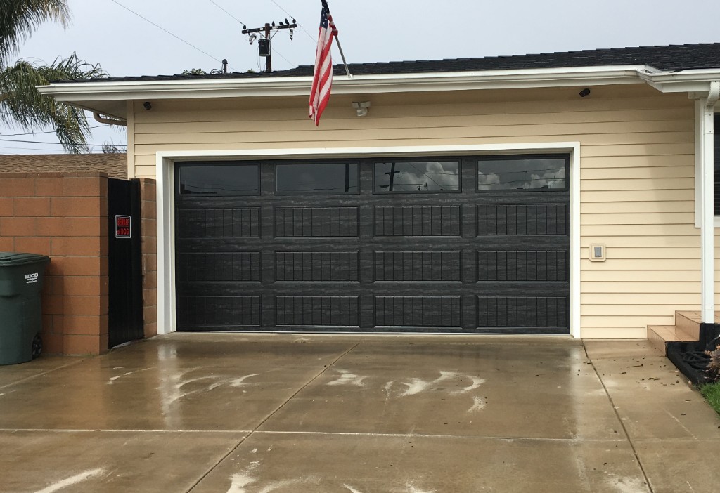 Residential home with sectional garage door and decorative window inserts
